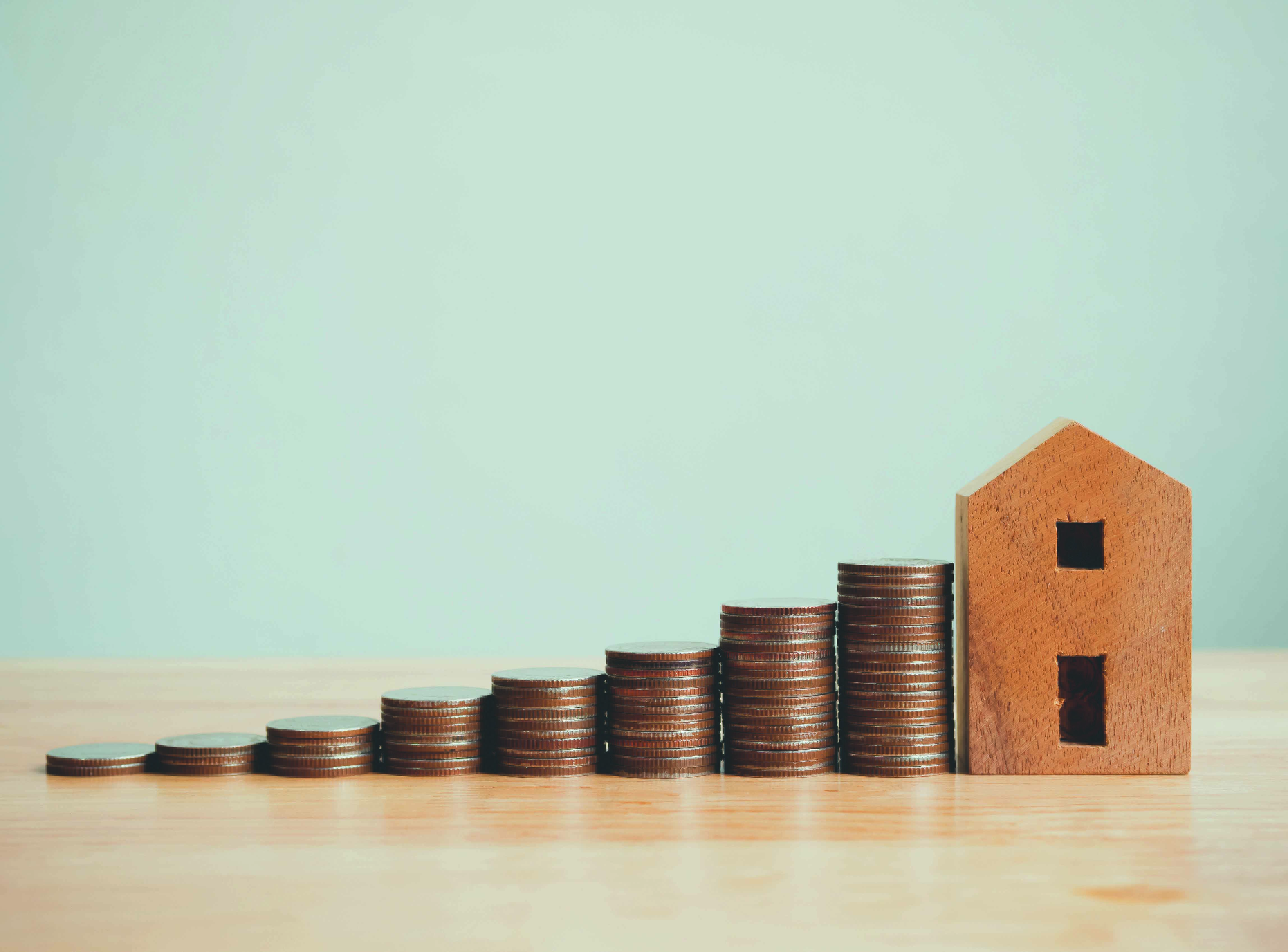 Property investment real estate and house mortgage financial concept, Money coin stack with wooden house