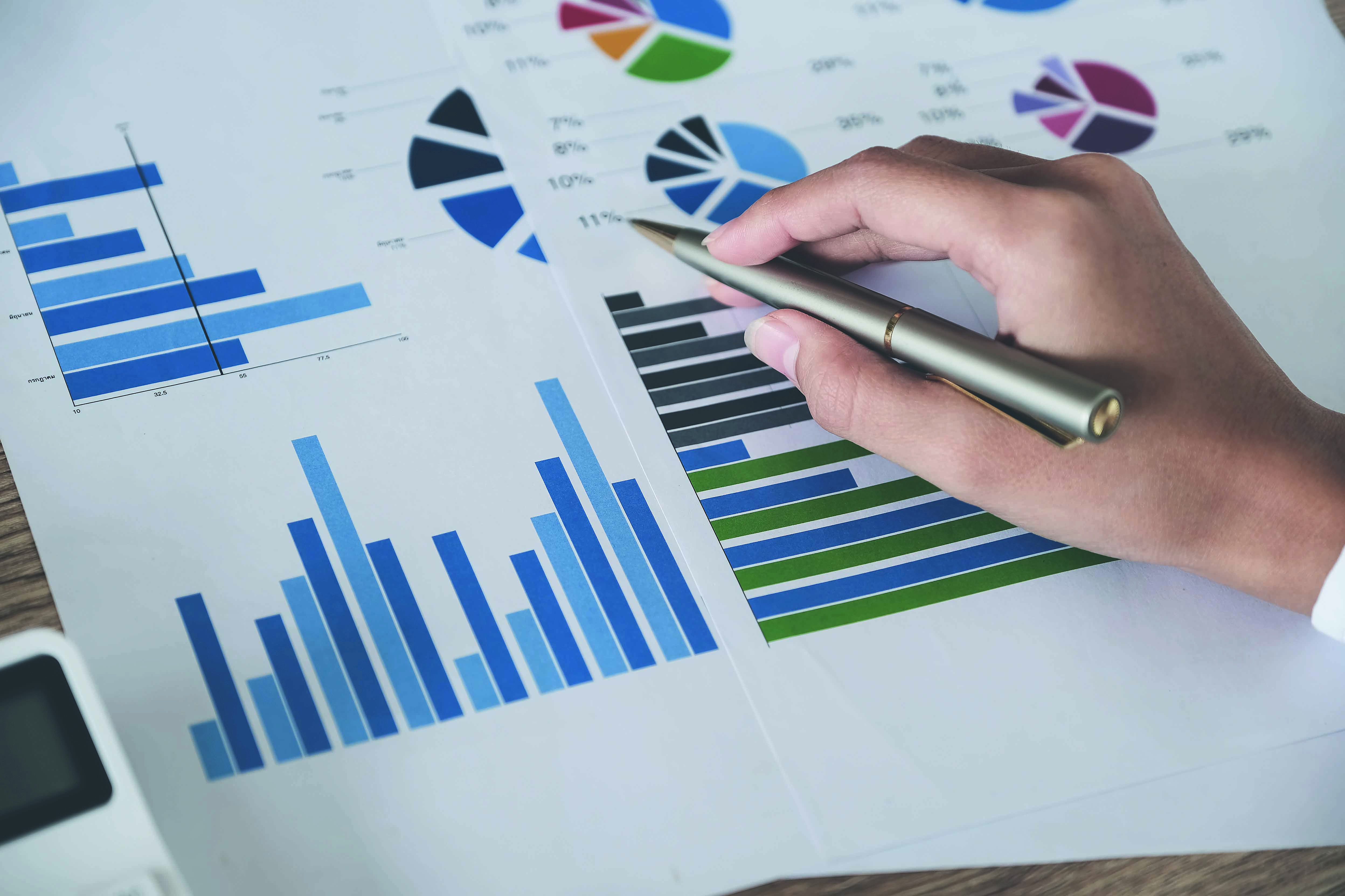 Business accounting concept, Business man pen pointing chart and using calculator to calculating budget and loan paper in office.