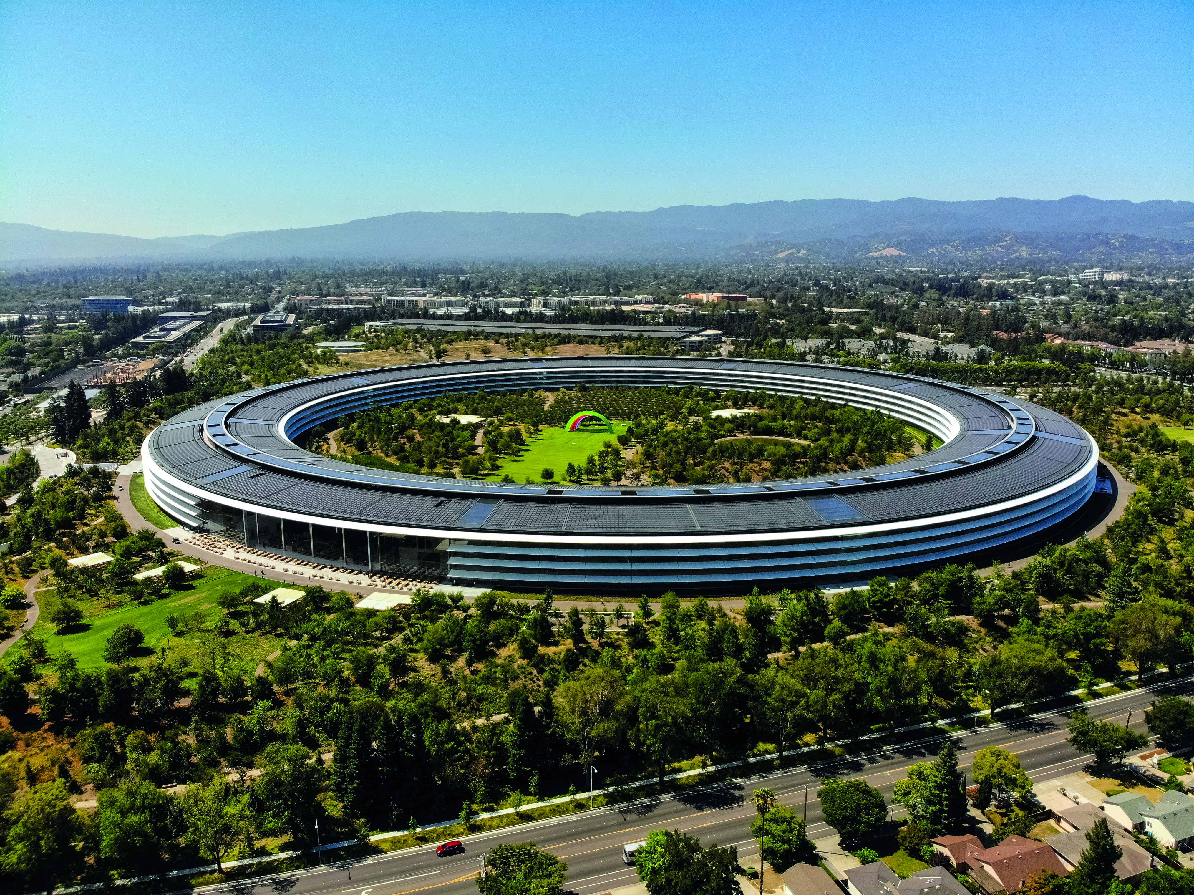 Sunnyvale, California, USA - July 30, 2019: Cars driving past Apple Park, an iconic building located in Sunnyvale California. This image was taken on the morning of July 30, 2019. Apple Park serves as the international headquarters of Apple, Inc. The roof contains solar arrays that power the building.